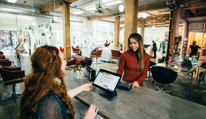 Two people making a transaction in a salon